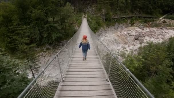 Young woman explores epic hanging bridge — Stock Video