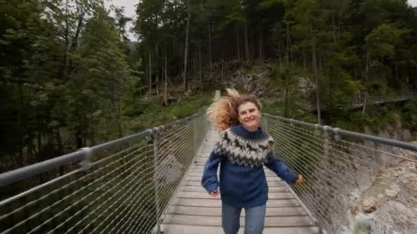 Junge Frau erkundet epische Hängebrücke — Stockvideo