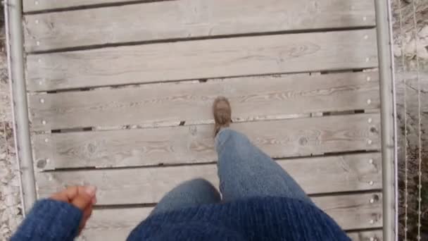 POV de botas caminando sobre puente de madera — Vídeo de stock