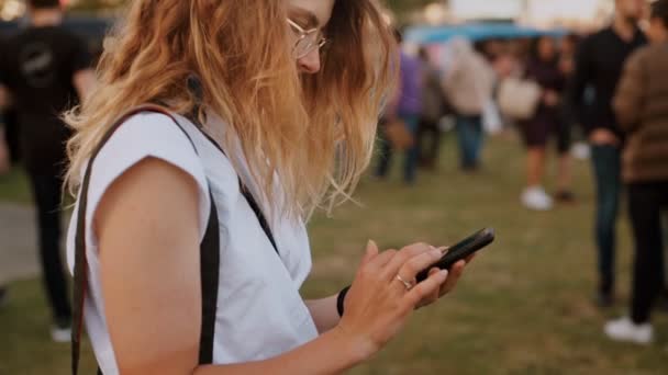 Hipster adolescente en el festival utiliza smartphone — Vídeo de stock