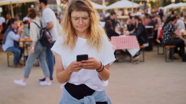 Hipster adolescente en el festival utiliza smartphone — Vídeos de Stock