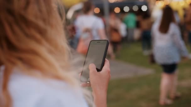 Hipster tiener op festival maakt gebruik van smartphone — Stockvideo