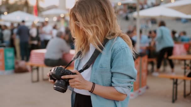 Девушка-фотограф, влияющая на блогера на фестивале — стоковое видео