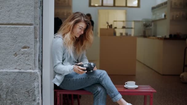 Жінка-фотограф блогер за столом кафе — стокове відео