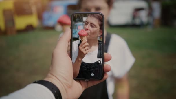 Cinemagraph teenager jíst zmrzlinu na smartphone — Stock video