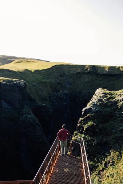 Young man on viewing platform in mountains