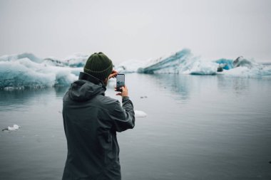 Gezgin veya turist buzdağları fotoğraflarını yapar