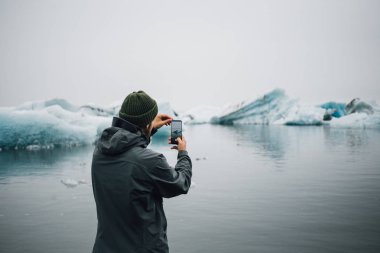 Gezgin veya turist buzdağları fotoğraflarını yapar