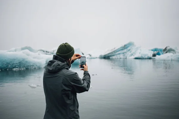 Traveler or tourist makes photos of icebergs — Stock Photo, Image