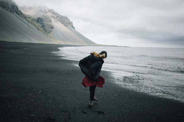 Young adventurous woman on black sand beach — Stock Photo, Image