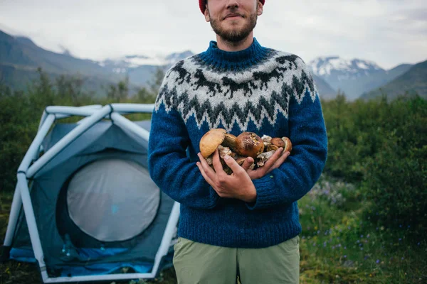 Young nomad hiker holds organic natural mushrooms — Stock Photo, Image