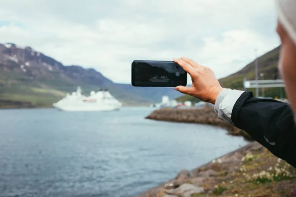 Frau macht Foto von Kreuzfahrtschiff in Fjord — Stockfoto