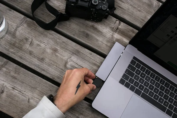 Fotógrafo transfiere archivos y fotos a la computadora portátil — Foto de Stock