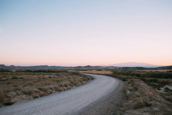 Camino vacío del desierto al atardecer o al amanecer — Foto de Stock