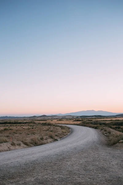 Empty desert road during sunset or sunrise