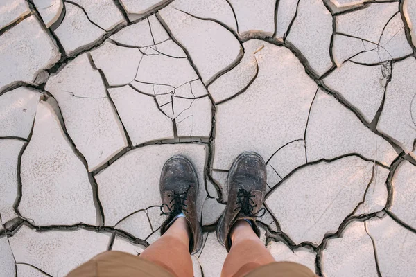 POV van wandelschoenen op droge grond bodem — Stockfoto