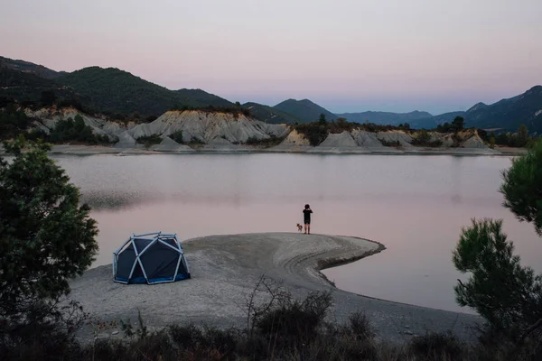 Ensam man står bredvid camping tält med hund — Stockfoto