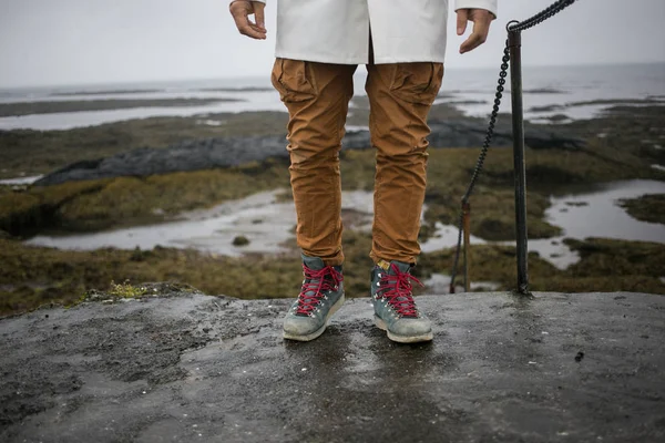 Turista en impermeable blanco camina en la orilla del hielo — Foto de Stock