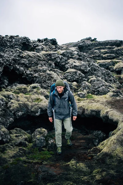 Homem jovem caminha através de terreno acidentado iceland — Fotografia de Stock