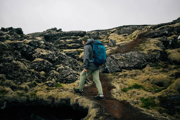 거친 아이슬란드 지형을 통해 젊은 남자가 인상 — 스톡 사진