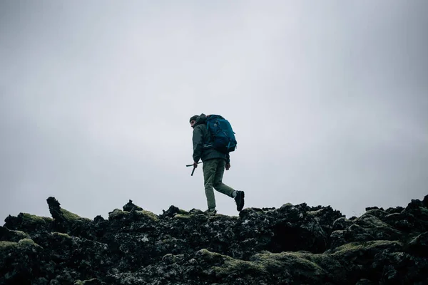 Young man hikes through rough iceland terrain