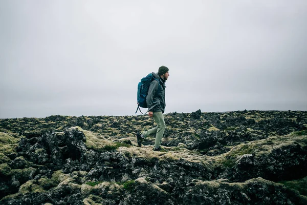 거친 아이슬란드 지형을 통해 젊은 남자가 인상 — 스톡 사진