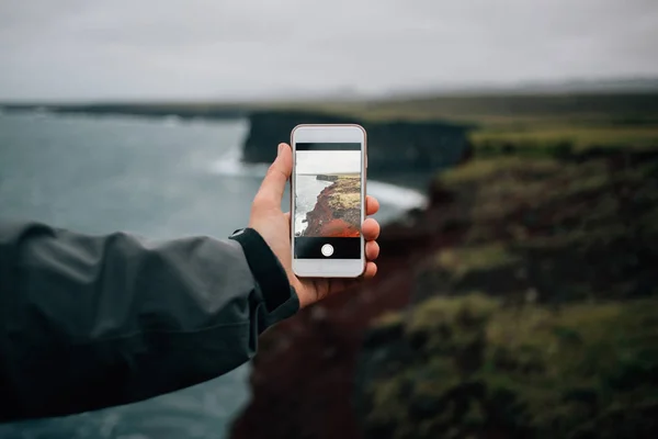 Main tient smartphone pour faire des photos de paysages — Photo