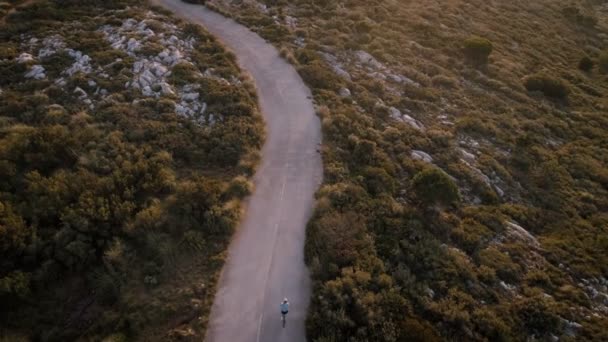 Aerial drone video of road cyclist at sunset — Stock Video