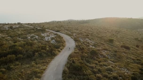 Vídeo de drones aéreos del ciclista de carretera al atardecer — Vídeos de Stock