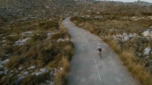 VÃ deo drone aéreo do ciclista de estrada ao pôr do sol — Vídeo de Stock