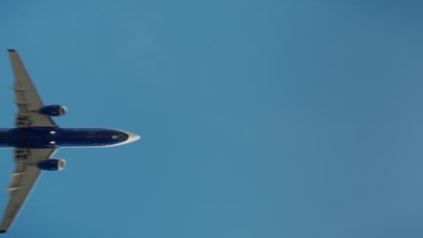 青い空を飛ぶ飛行機の対称のショット — ストック動画