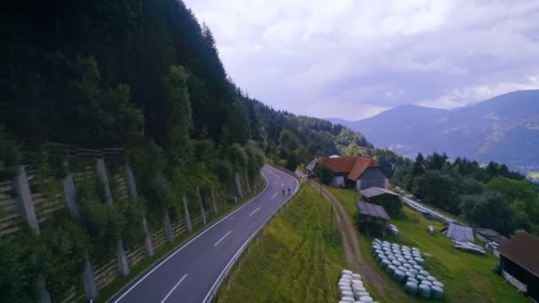 Пара велосипедистов едет по горной дороге — стоковое видео