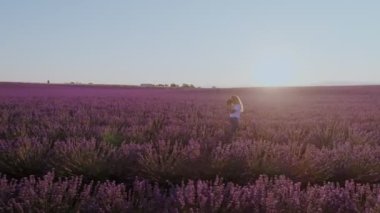 Bin yıllık hippi kıyafet, serbest fotoğrafçı veya sosyal medya internet etki unsuru veya blogger, genç güzel kadın kamera ile rüya gibi puple lavanta alanlar ile yürür. İçerik Oluşturucu göçebe
