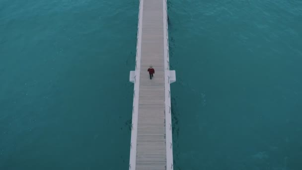 Hombre caminar en infinito interminable muelle de madera o puente — Vídeo de stock