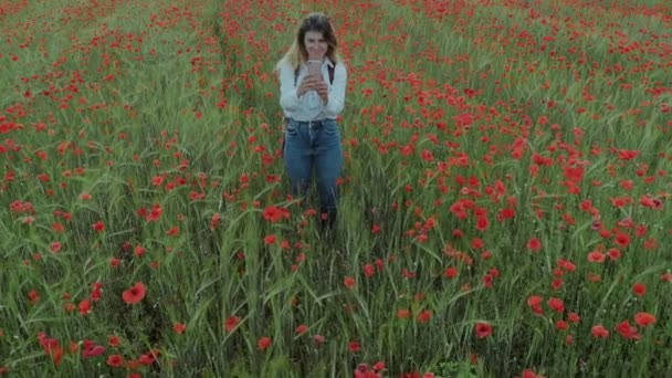 Молодая женщина-блогер на цветочном поле — стоковое видео
