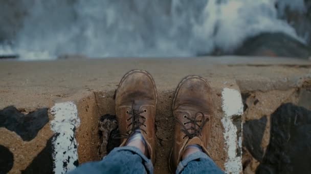水の上の崖の端に古いハイキング ブーツ — ストック動画