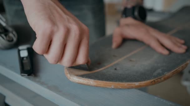 Skateboarder greift in Werkstatt nach Brettspielzeug — Stockvideo