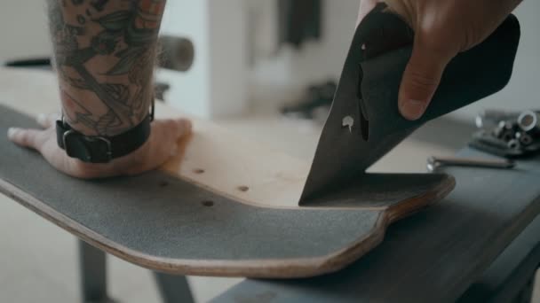 Skateboarder regrips board diy en el taller — Vídeo de stock