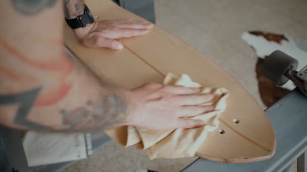 Skateboarder regrips board diy en el taller — Vídeo de stock