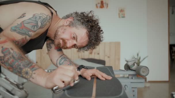 Skateboarder regrips board diy en el taller — Vídeo de stock