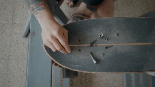 Skateboardista regrips deska kutilství v dílně — Stock video