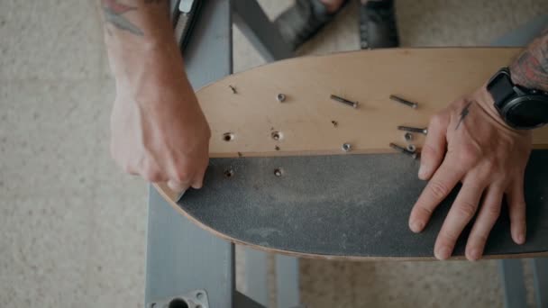 Skateboardista regrips deska kutilství v dílně — Stock video