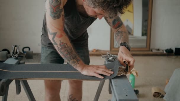 Skateboarder regrips bordo fai da te in officina — Video Stock