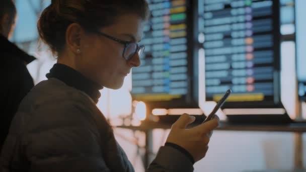 Viajera en la terminal del aeropuerto con teléfono — Vídeo de stock