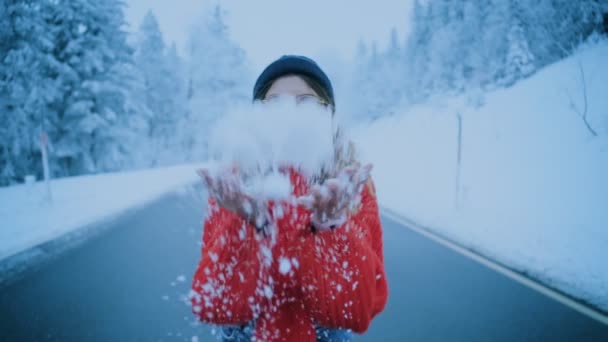 Χαριτωμένο κορίτσι ρίχνει χιόνι στον αέρα και ευτυχείς χαμόγελα — Αρχείο Βίντεο