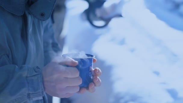 Hombre sostiene taza de camping azul con café caliente — Vídeos de Stock