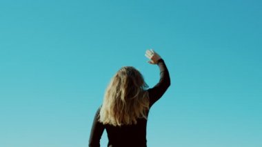 Sarışın genç kadın dalgalar hoşçakal veya gökyüzü Merhaba