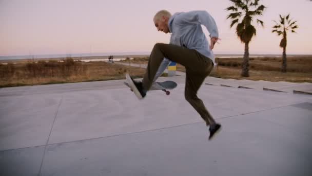 Paseos en patineta hipster Millennial en la puesta del sol — Vídeo de stock