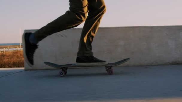 Paseos en patineta hipster Millennial en la puesta del sol — Vídeo de stock