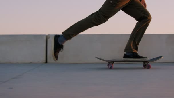 Paseos en patineta hipster Millennial en la puesta del sol — Vídeos de Stock